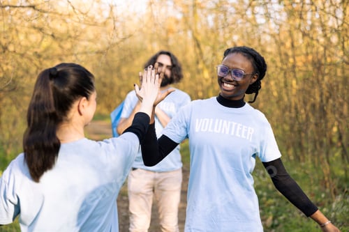 Preview: Satisfied diverse women sharing a high five feeling proud of their hard work
