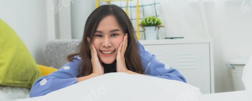 Preview: Smiling Woman Relaxing on Bed in Comfortable Room