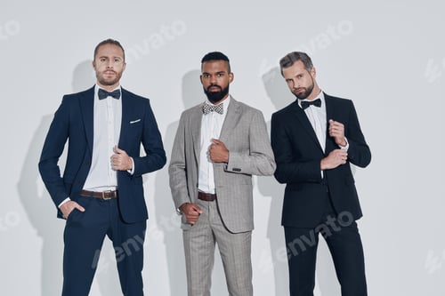 Preview: Three handsome young men in suits and bowties looking at camera