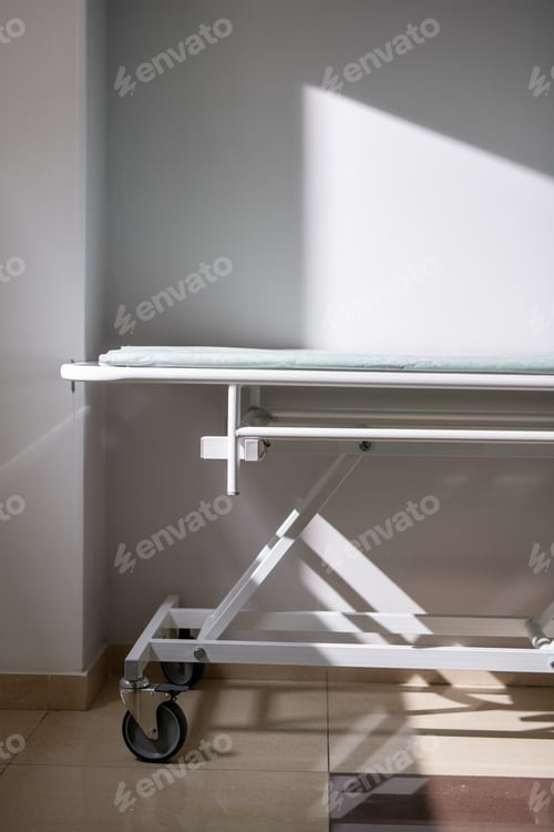 Preview: Empty medical cart standing by wall and window in hospital chamber or corridor