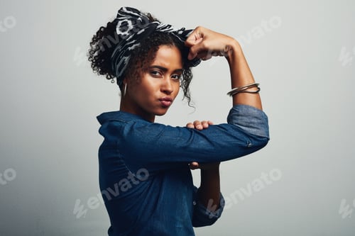 Preview: Confident Woman Flexing Arm Muscles in Studio