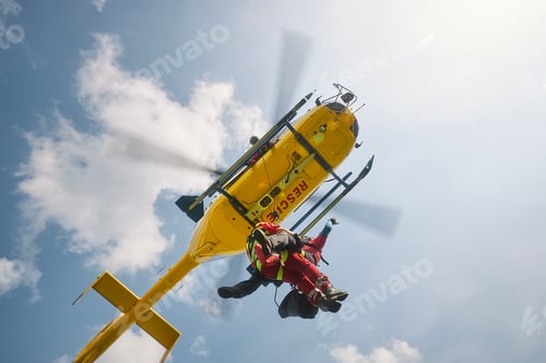 Preview: Two paramedics hanging on rope under flying helicopter