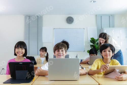 Visualização: Diversidade de alunos do ensino fundamental estudando em sala de aula com dispositivos digitais