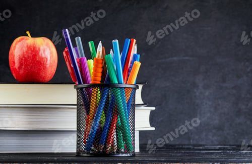 Preview: Back to school background with books and apple over blackboard with copy space.