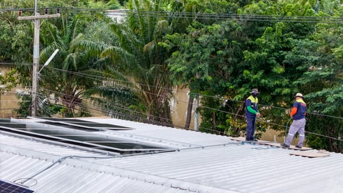 Preview: Solar panels installed on a corrugated metal roof, with technicians working