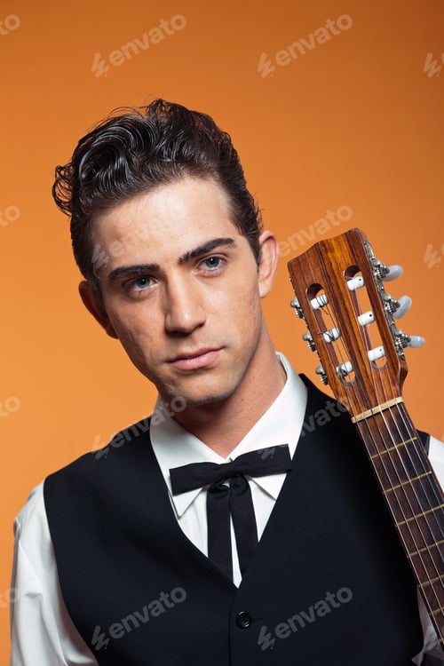 Preview: Close-Up Portrait Of Retro Country Male Guitar Player In Black Suit. Studio Shot.