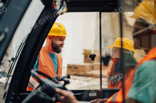 Preview: Warehouse workers in hard hats communicating via forklift window.