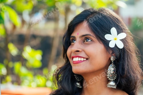 Preview: cheerful young indian woman with white flover in hair relaxing on beach in Goa