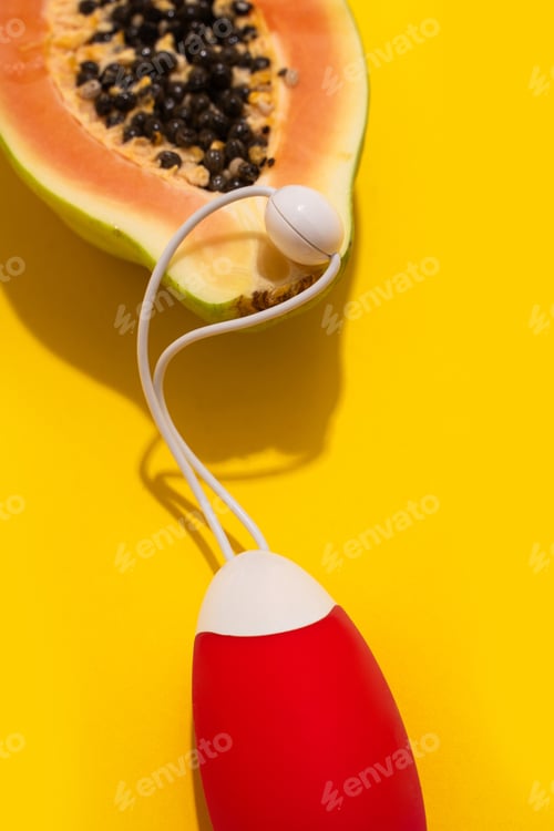 Preview: Vibrator adult toy with ripe papaya on yellow background