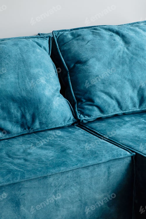 Preview: Close up view of blue suede sofa and cushions.