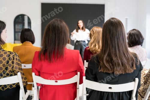 Preview: Rear view of unidentified people listening to coach having speech at business training