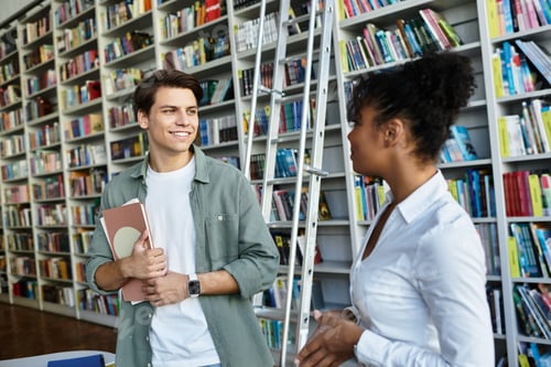 Preview: Dedicated teacher inspires eager student in a vibrant library setting during a learning session