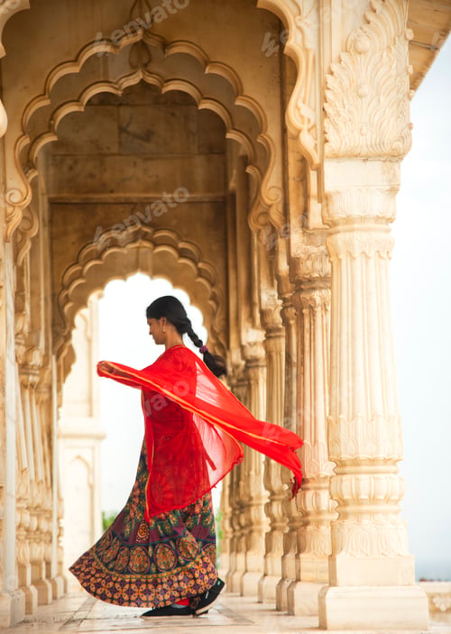 Preview: Young female tourist dancing between arches and Pillars.