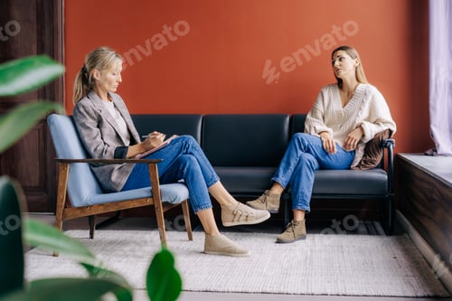 Preview: A female psychotherapist attentively listens and counseling a young woman talking about problems.