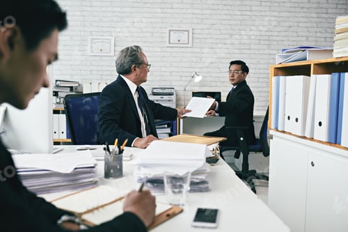 Businessmen Conferring with Associate in Modern Office