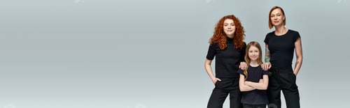 Preview: three generations of stylish women in matching clothes standing on grey background, banner