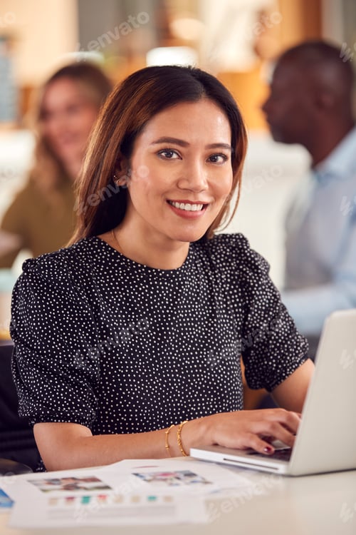 Preview: Portrait Of Mature Businesswoman In Wheelchair Sitting At Desk Working On Laptop In Busy Office