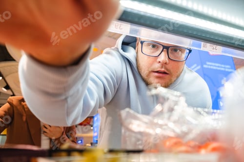 Preview: Man looking for Products on Shelf Couple Customers Shopping With Checklist
