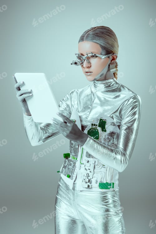 Preview: silver robot with eye prosthesis looking at tablet isolated on grey, future technology concept