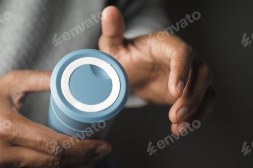 Preview: Hands holding a blue container in soft light
