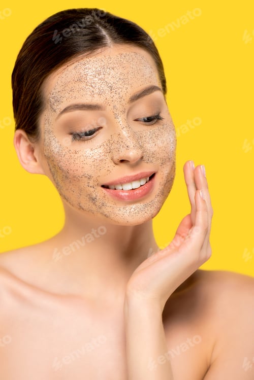 Preview: portrait of smiling naked girl applying peeling mask, isolated on yellow