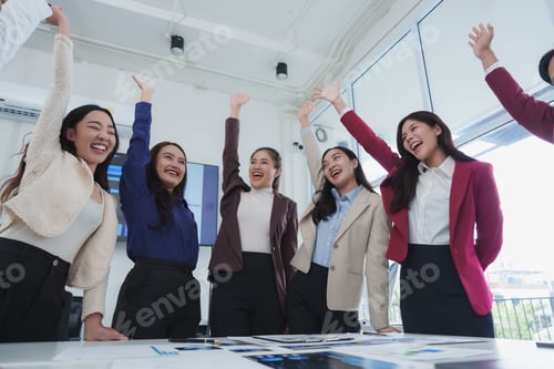 Preview: Excited businesswomen celebrating success raising hands in office meeting