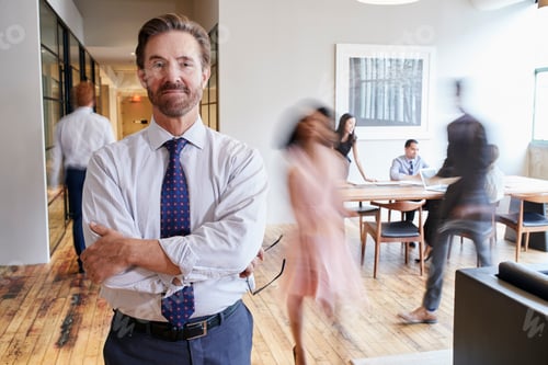 Preview: Portrait of middle aged white man in a busy modern workplace