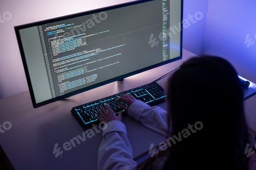 Preview: Silhouetted Figure Engaged in Computer Hacking Activities at Night