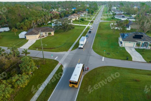 Preview: Top view of classical american yellow school bus picking up kids at rural town street stop