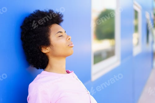 Preview: Black woman standing near building