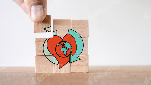 Preview: Hand putting the last piece of a wooden puzzle with happy earth day symbol