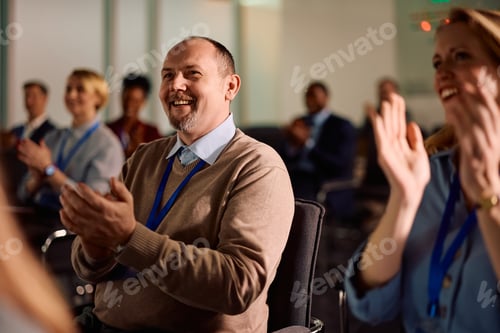 Preview: Happy businessman applauding after successful education event in board room.