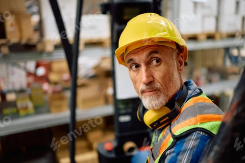 Preview: Senior worker operating a forklift in reverse while loading cargo in a warehouse.