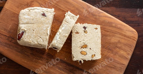 Preview: Halva almond nuts slices on wooden table background