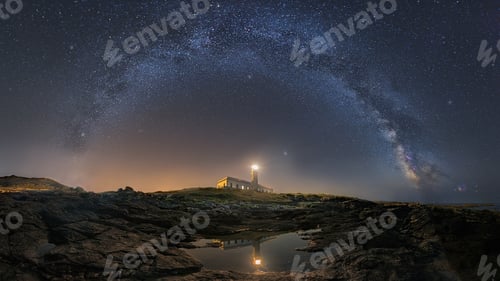 Preview: Beautiful landscape view of half cloudy circle on a lighthouse reflecting on water at night
