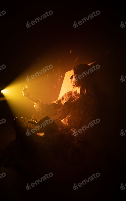 Preview: girl in a ray of magic light with an open book and a glowing crystal
