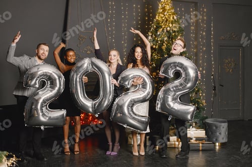Preview: Male and female friends in standing with balloons 2022 for New Year's celebration