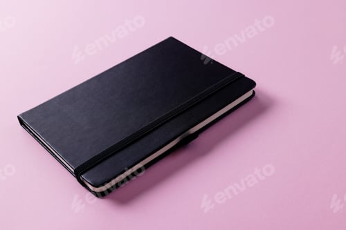 Preview: Close up of black notebook with copy space on pink background
