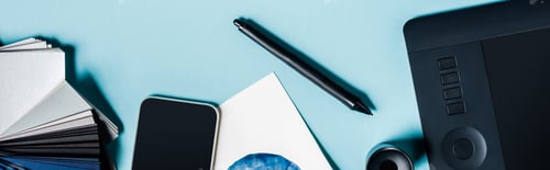 Preview: Panoramic shot of graphics tablet, smartphone and color samples on blue background
