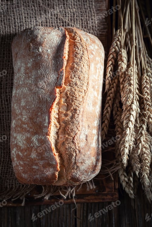 Preview: Homemade and tasty loaf of bread with grain and ears.