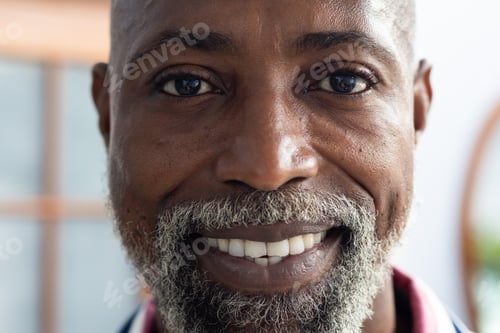 Preview: Portrait of happy african american male doctor looking at camera and smiling at doctor's office
