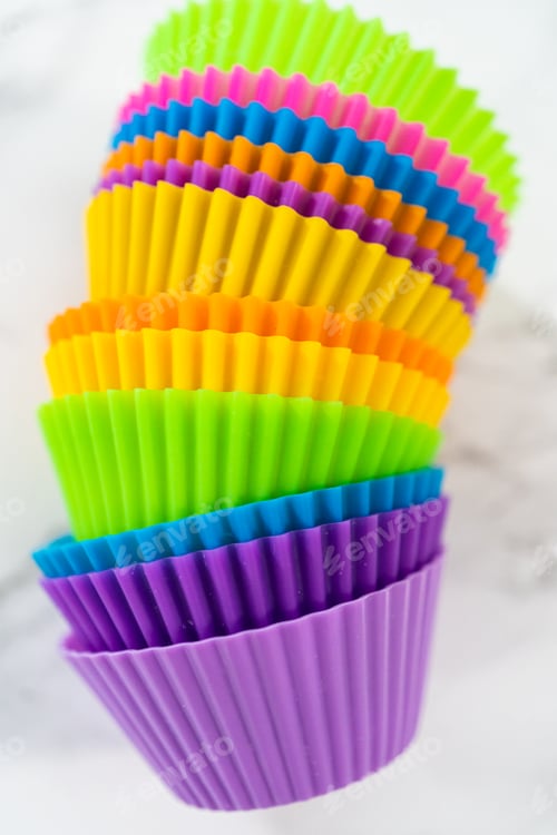 Preview: Stack of Colorful Cupcake Liners on White Surface