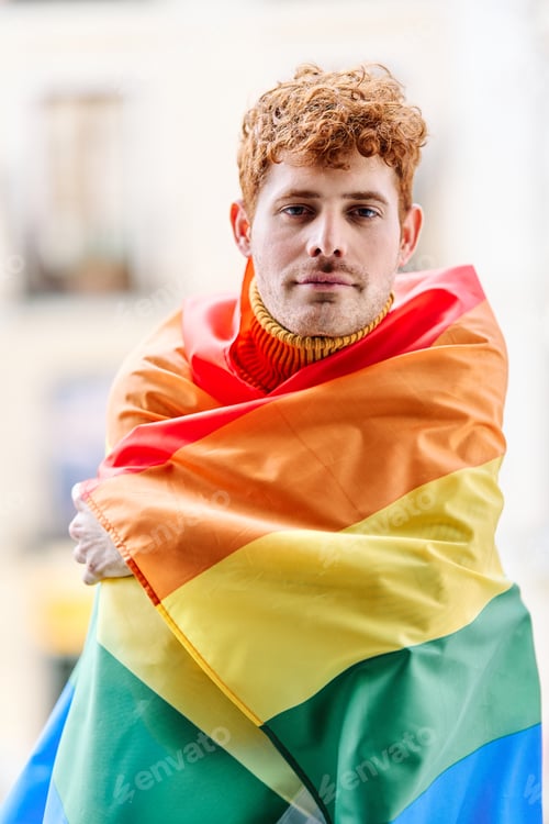 Preview: Redheaded gay man wrapping with a rainbow lgbt flag