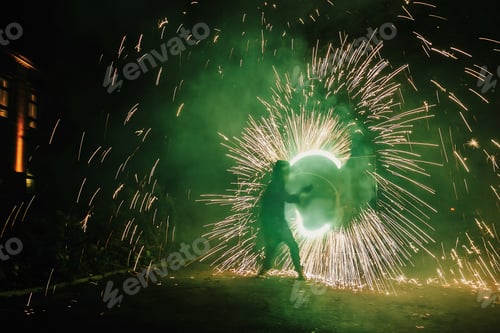 Preview: Fire dancers swing, spinning green fire and man juggling with bright sparks in the night