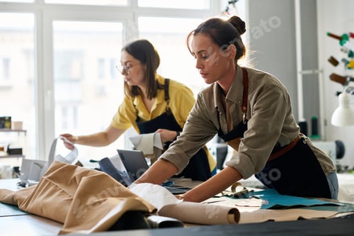 Preview: Young female tanner working with sewing patterns and leather textile