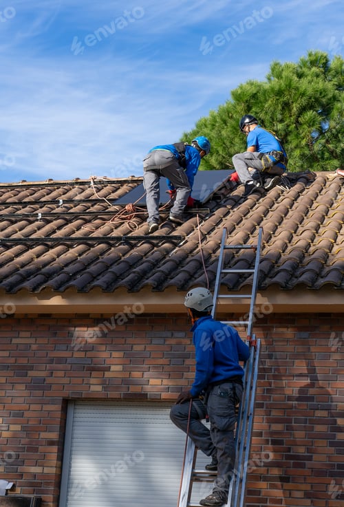 Preview: Three workers installing solar panels in a residence
