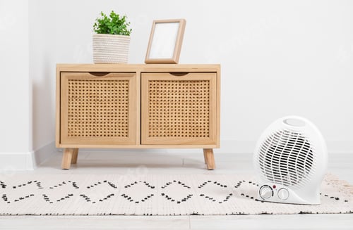 Preview: Electric fan heater on floor at home. Space for text
