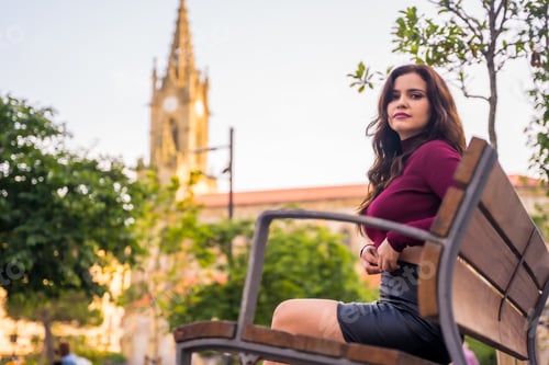 Preview: Portrait of a brunette woman in a leather skirt sitting in the city, lifestyle, fashion pose