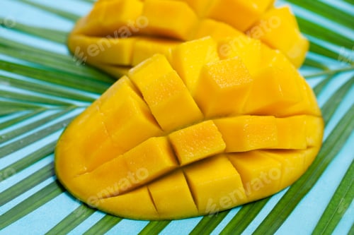 Preview: Fresh Mango on a Palm Leaf. Blue Background. Close up.