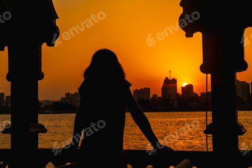 Preview: A Young Woman Looking At The Orange Sunset On The Nile River From A Boat, The Sun Is Hiding In The